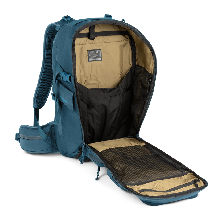 35L Mission Backpack (Wander Blue) with open compartment showing Coyote interior on a white background / Wander Blue