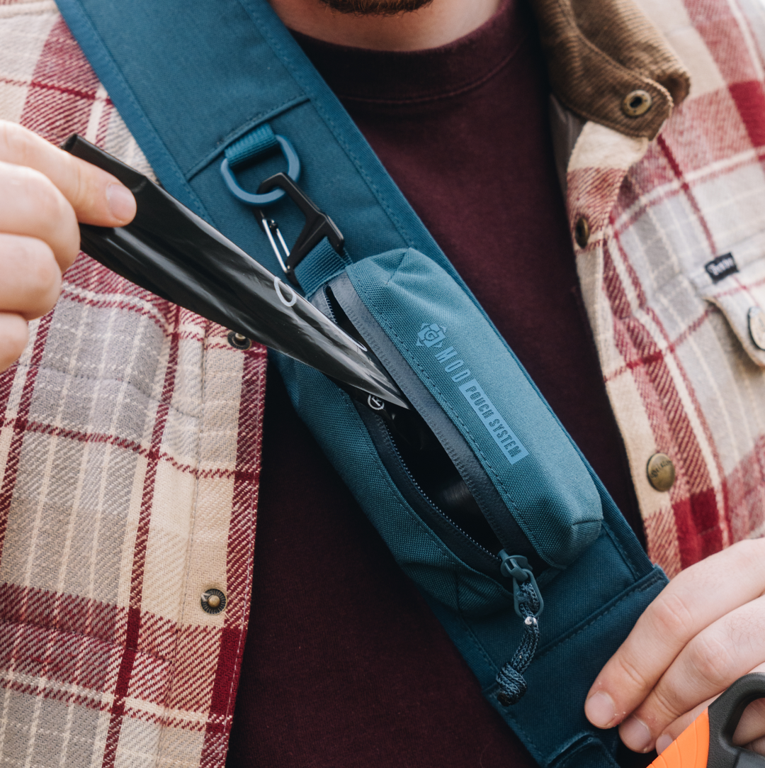 G-MOD Pod Pouch System shown in Wander Blue. Demonstrating the versatility of the system and how it can even be utilized as a "poop" storage system for doggie poop bag dispensing.