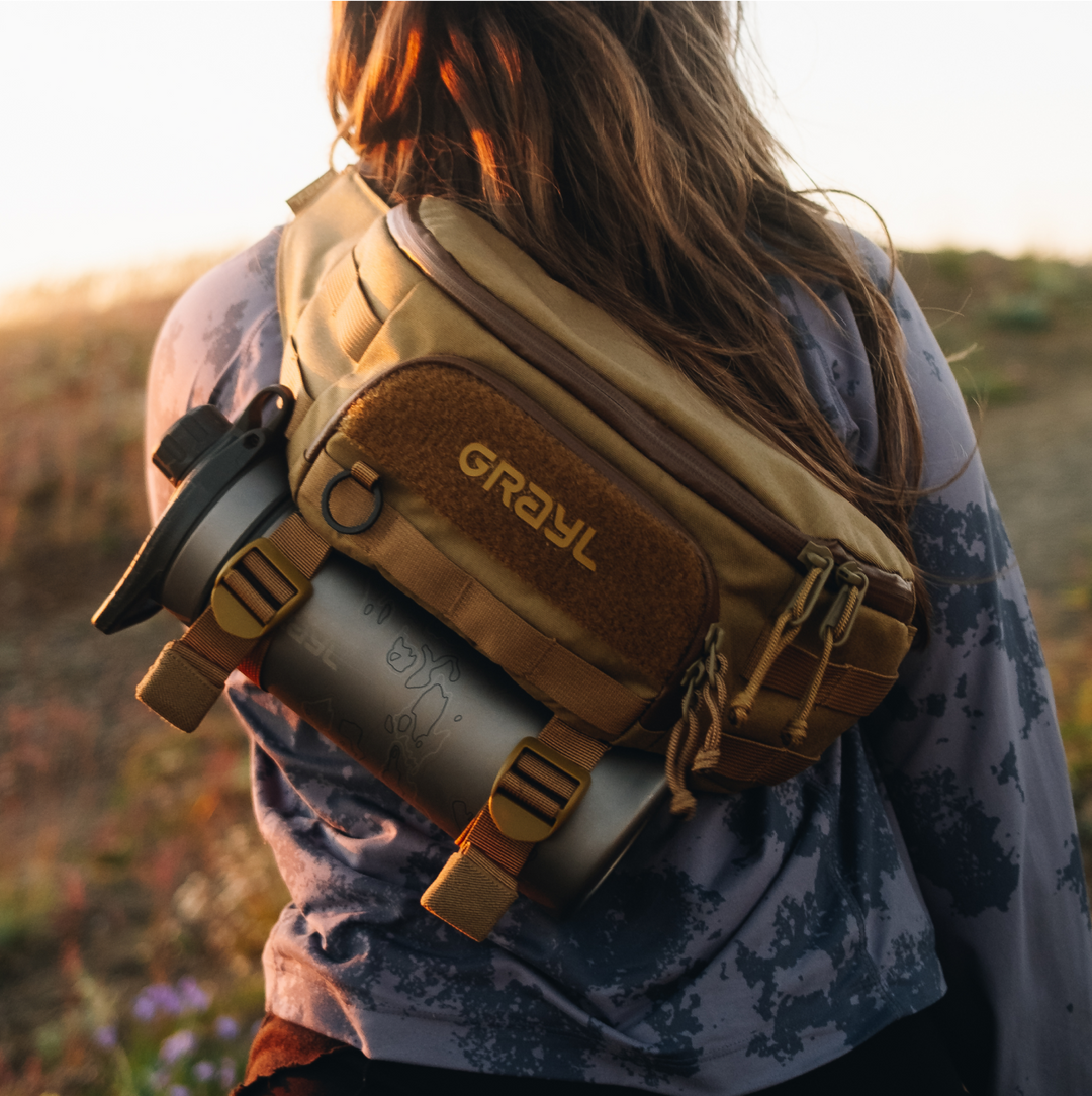 4L Transport Hip Pack in Coyote Brown colorway worn crossbody on female hiker's backside with GeoPress Titanium Water Filter and Purifier Bottle in BottleLock Tie Down System.